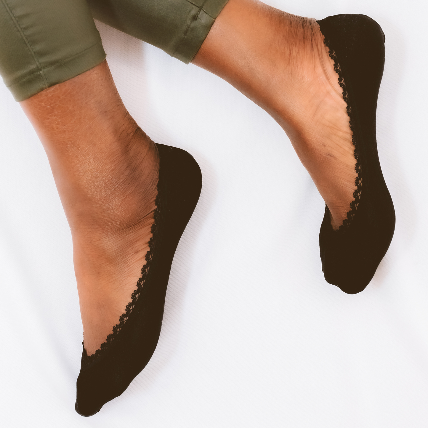 Close-up of black woman wearing black loafers with black lace edge peeking out - Arbella Style detail