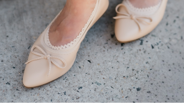 White woman wearing nude ballerina flat with Arbella Style footie edge peeking - top of foot comfort and coverage