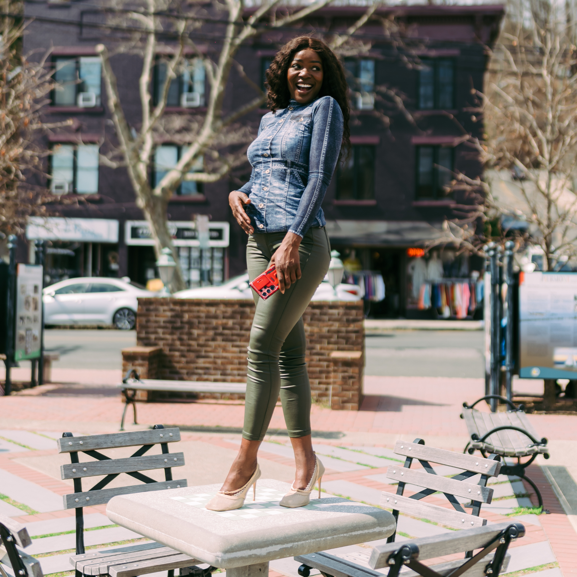 Woman standing powerfully on table wearing sand heels with footies - Arbella Style casual day confidence